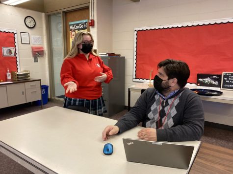 Woodlands Academy Student discusses an assignment with history teacher, Mr. Sands, while wearing masks.